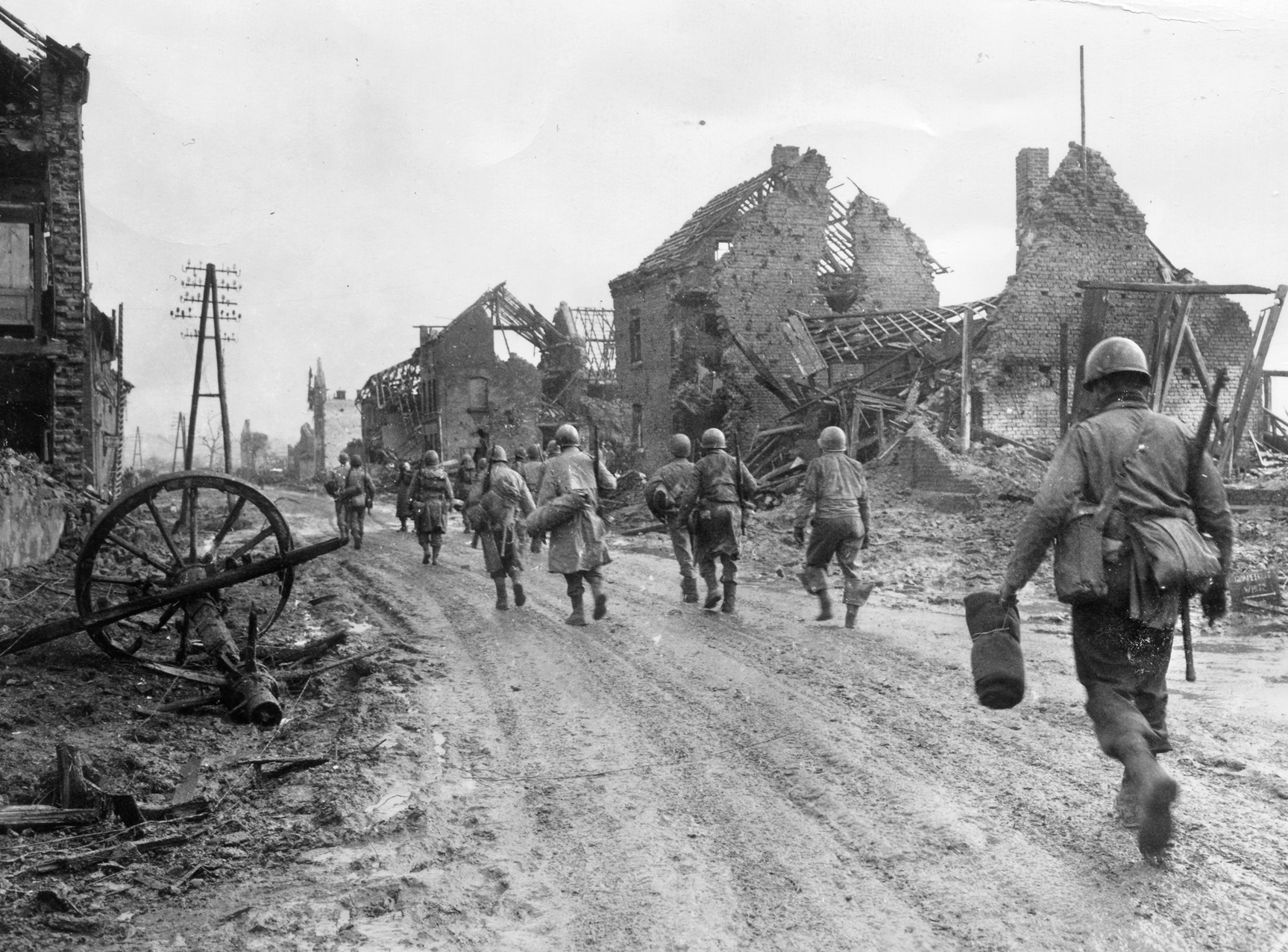Men of the 121st Infantry Regiment, 8th Infantry Division, head out of the destroyed town of Hürtgen and advance toward Kleinau and the start of the attack to capture the Brandenberg-Bergstein Ridge.